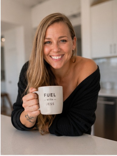 Jess holding her Fuel with Jess mug in the kitchen